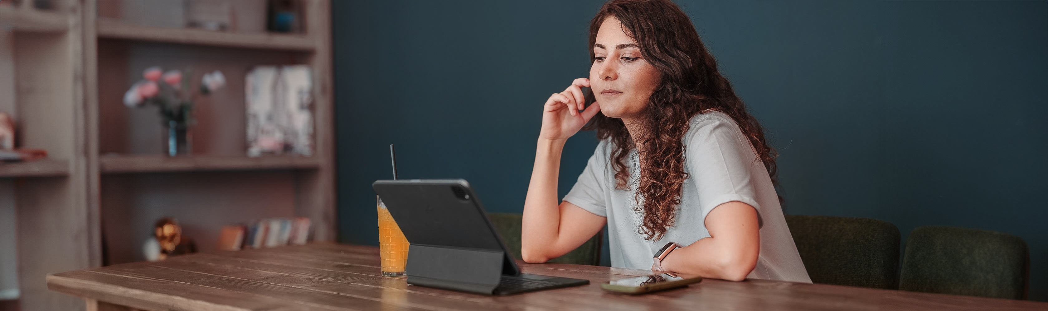 Frau sitzt nachdenklich vor dem Tablet
