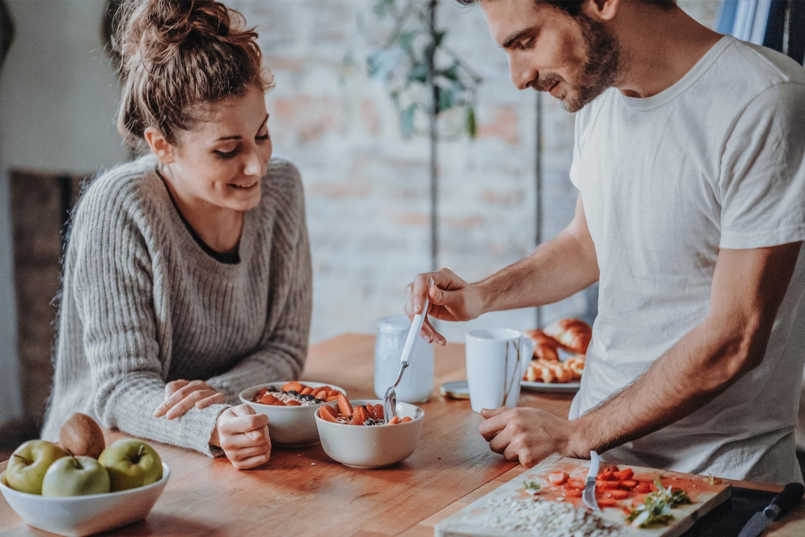 Schwanger werden – Paar ist am Küchentisch und essen eine nahrhafte Bowl mit Früchten