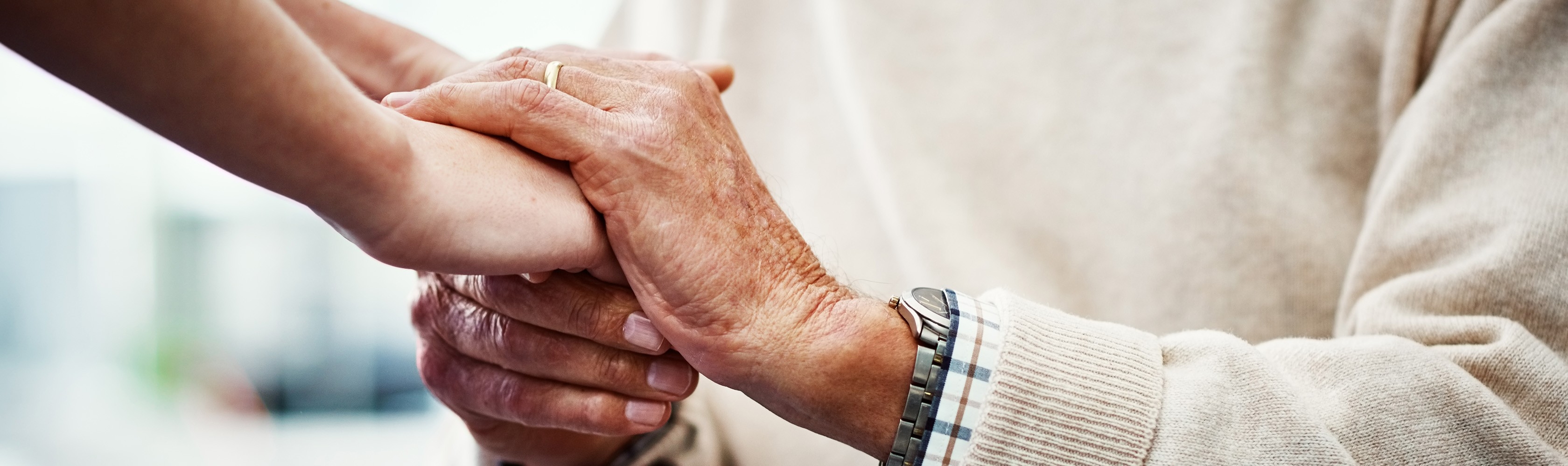 Junge Hände halten alte Hände. 