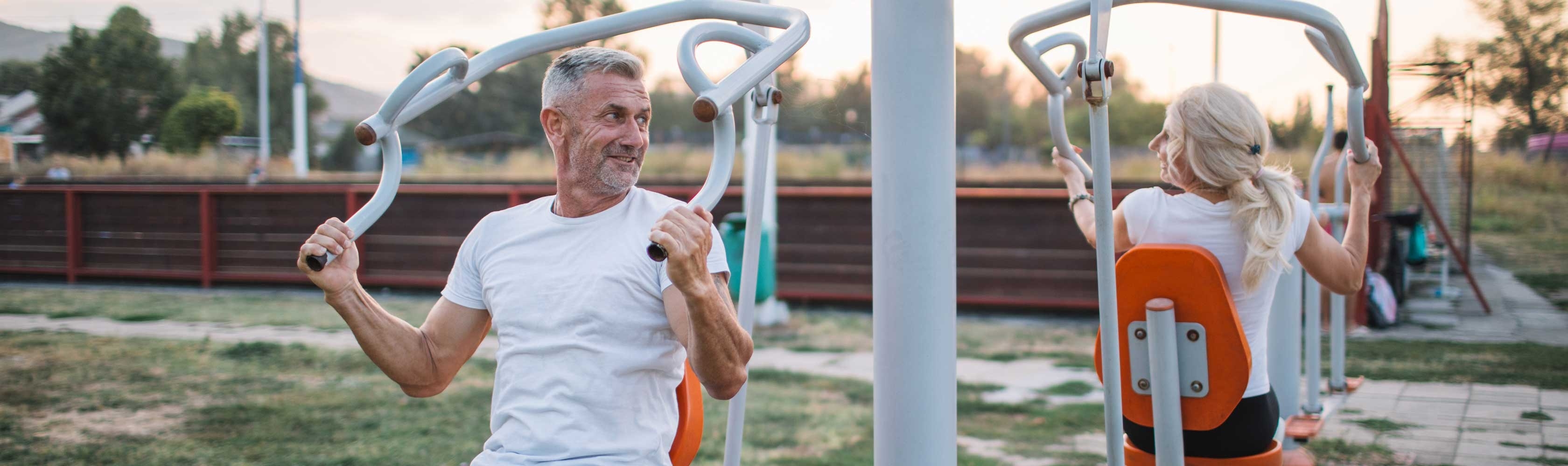 Ein Mann und eine Frau auf einem Outdoor-Krafttrainingsplatz.