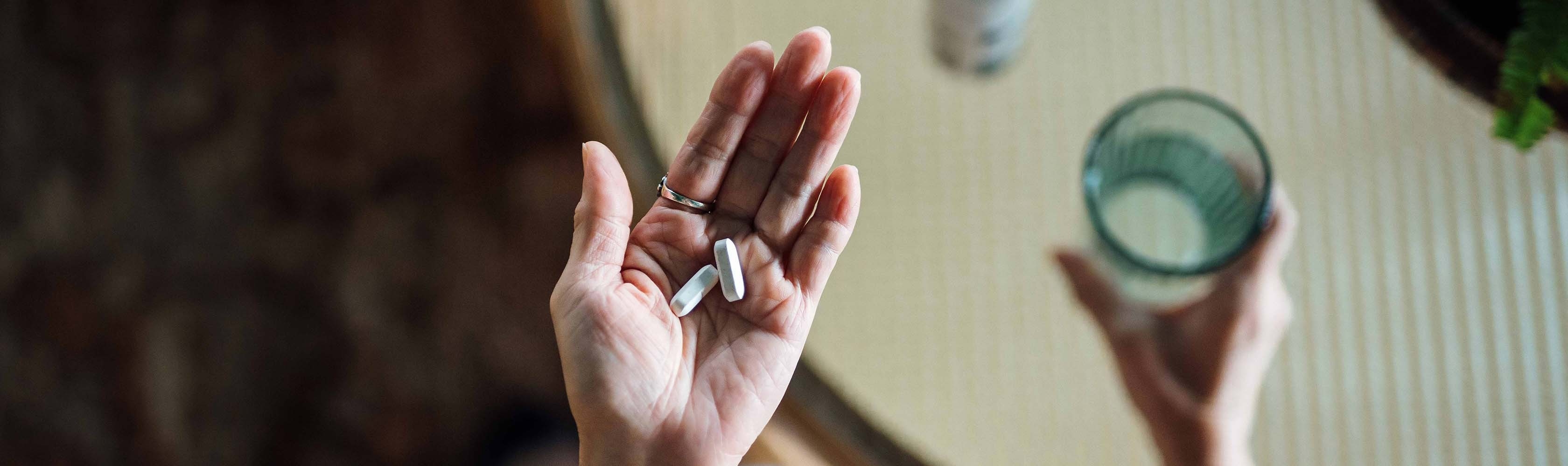 Eine Person hält Medikamente zur Einnahme in der Hand
