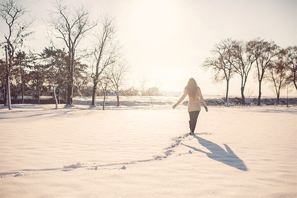 Eine Frau spaziert im Schnee