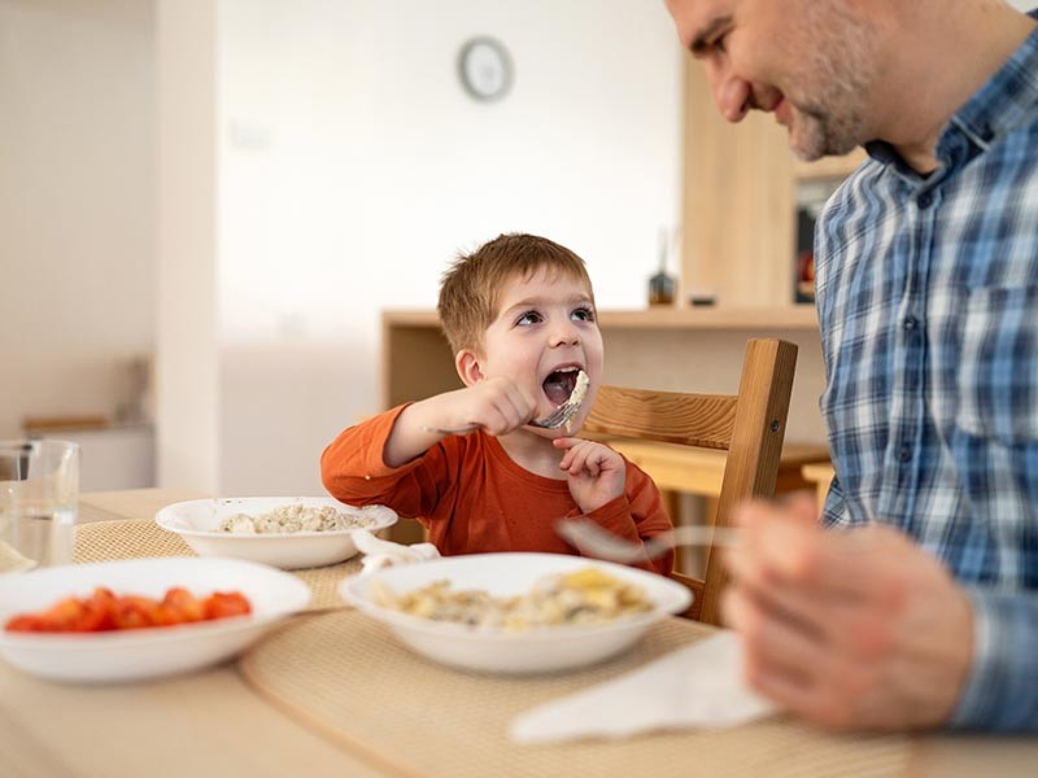 Ein kleiner Junge isst Älpler Magronen mit seinem Vater.