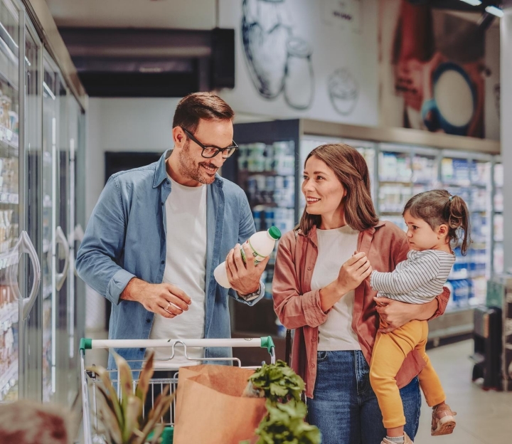 Ein Mann, seine Frau und ihre kleine Tochter machen einen gesunden Einkauf.