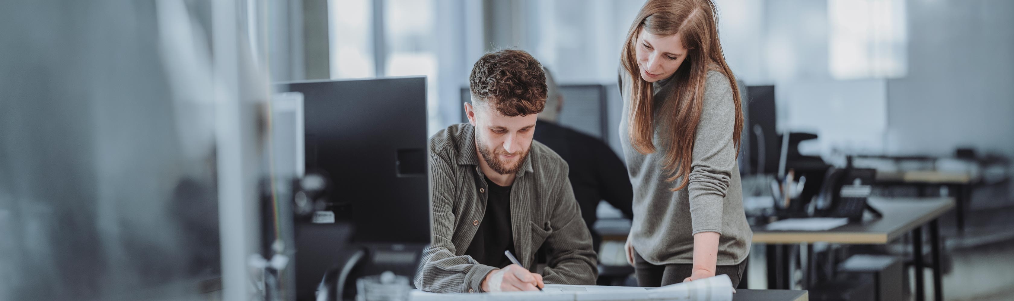 Geschäftsbericht 2025 - Ein Mann und eine Frau arbeiten im Büro