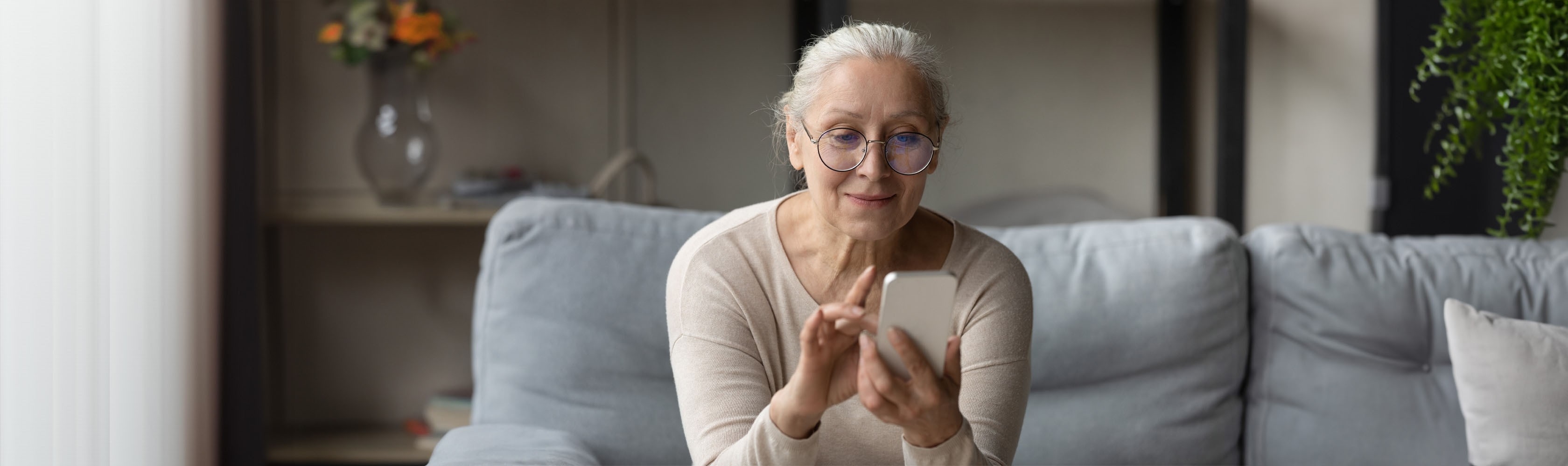 Ältere Frau benutzt auf dem Smartphone eine Prävetions-App.
