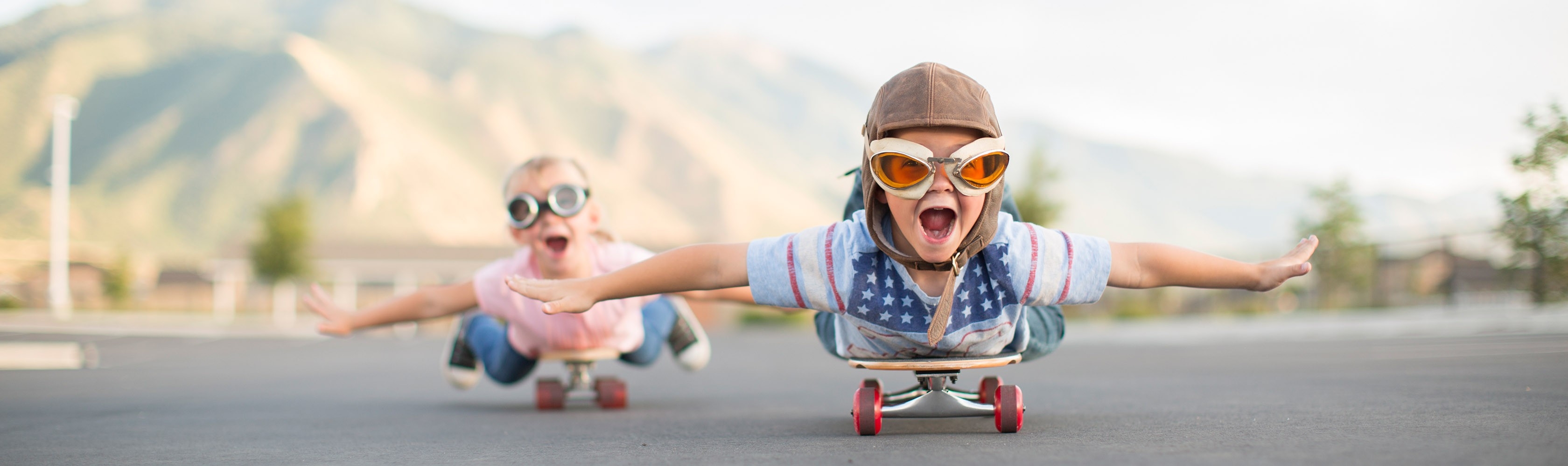 Zwei Kinder toben sich auf ihren Skateboards aus.