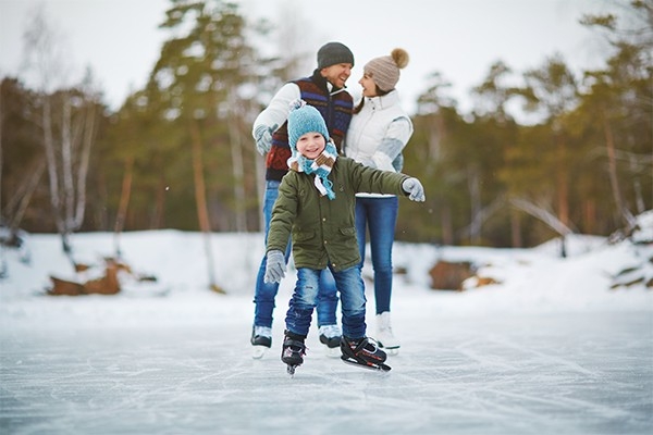 Eine Familie beim Eislaufen. Draussen aktiv sein, hilft, über die Feiertage das Gewicht zu halten.