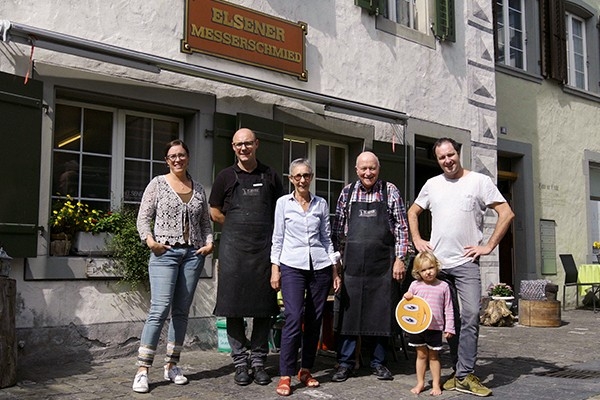 Drei Generationen der Familie Elsener vor ihrem Haus, das gleichzeitig Wohnhaus und Messerschmiede sowie Verkaufsfläche ist. Hier leben und arbeiten alle zusammen – von den Grosseltern über die Kinder bis zu den Enkeln. 