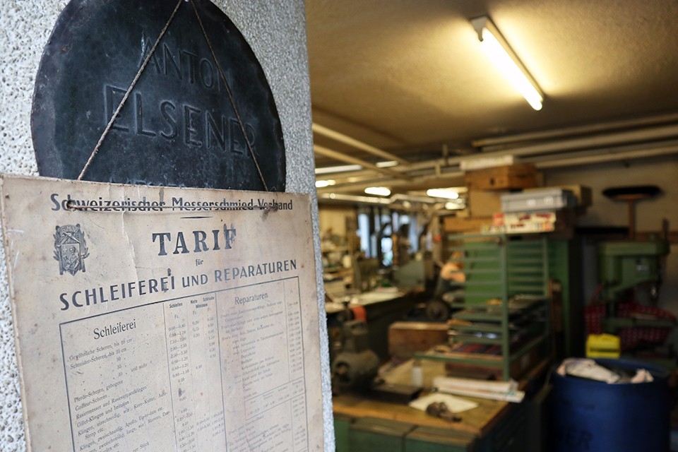 Generationen. Familie. Eingang zur Werkstatt mit einem alten Tarifblatt an der Türe.