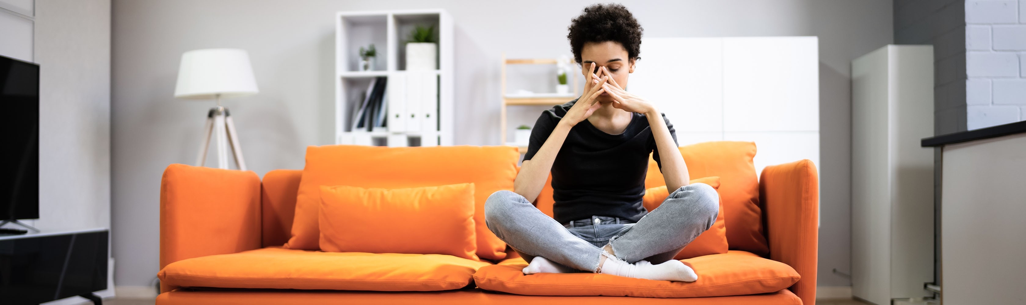 Eine Frau sitzt auf dem Sofa und hat Liebeskummer.