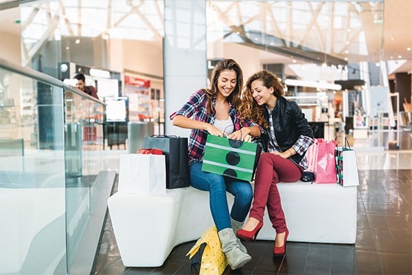 Zwei Teenager-Mädchen sitzen im Einkaufszentrum und begutachten ihre Shopping-Beute. Die Freude ist gross – ebenso wie der Markendruck.
