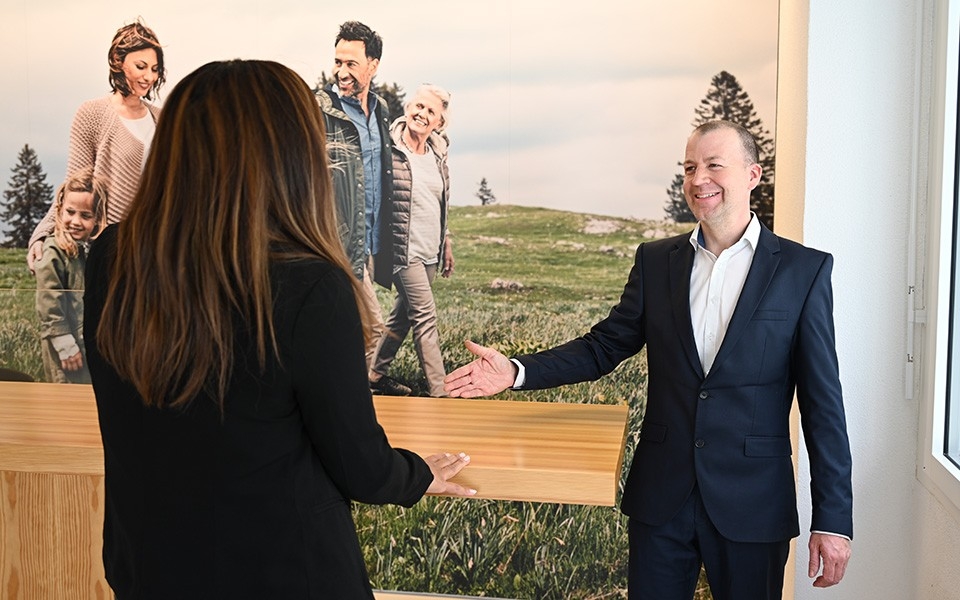 Julien Galand empfängt eine Kundin in seiner CONCORDIA Agentur in Yverdon
