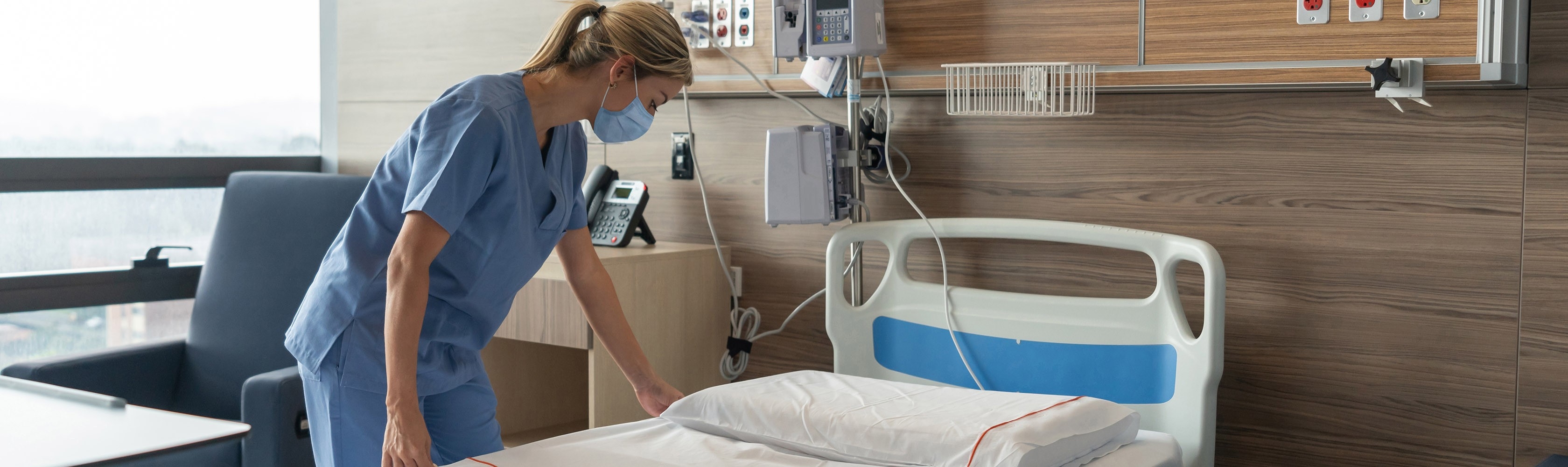 Eine Pflegeperson macht ein Spitalbett bereit