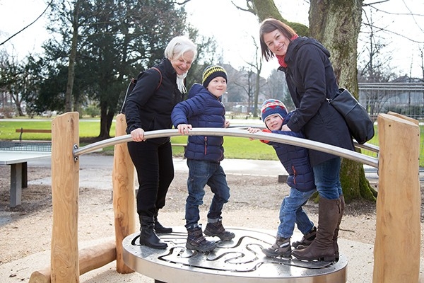 Eine ganze Generation in Bewegung. Ein Mutter, ihre beiden Kinder und die Grossmutter testen zusammen ihre Balance auf einem Geräte im Bewegungspark der Stiftung Hopp-la