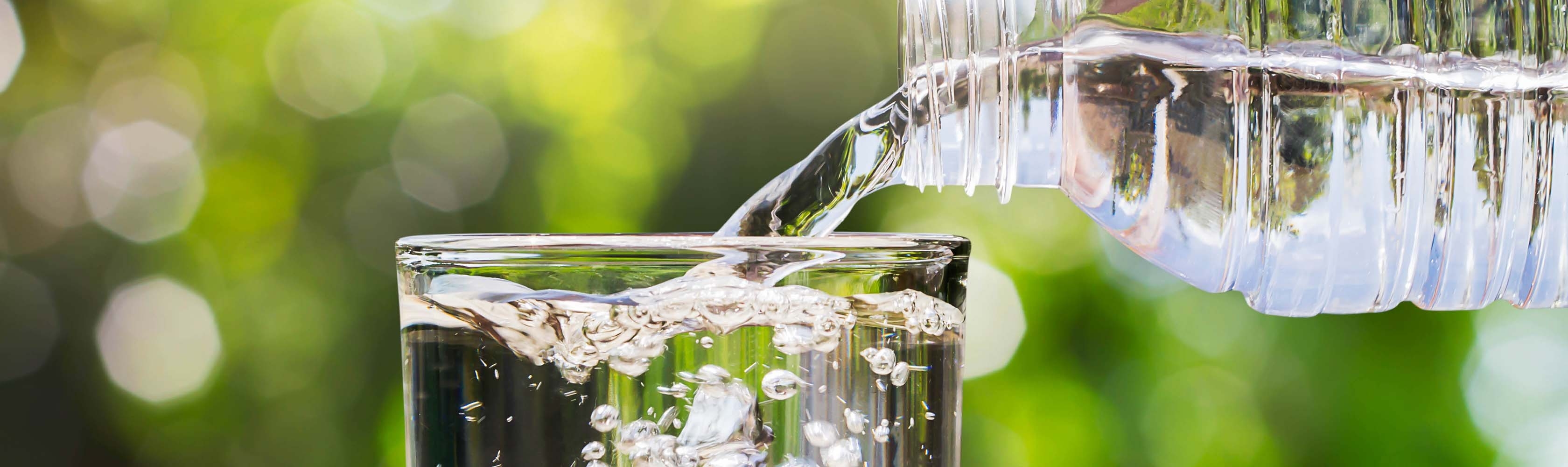 Ein Glas Wasser wird aufgefüllt. Weisheiten rund ums Trinken und die Gesundheit.